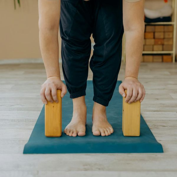 A person balancing on one leg in a modern, calm studio environment.